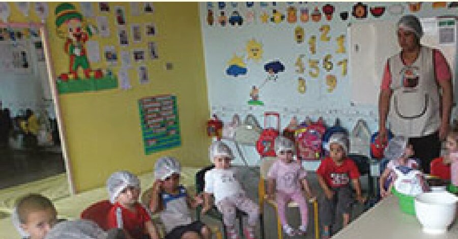 Crianças e uma educadora em sala de atividades do Centro de Educação Infantil São José